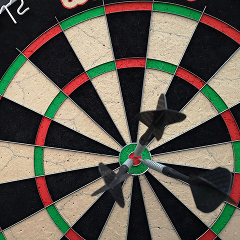 A close up shot of a dartboard with darts on the bullseye
